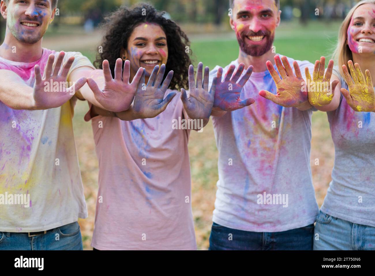 Groupe d'amis posant avec des mains colorées Holi Banque D'Images