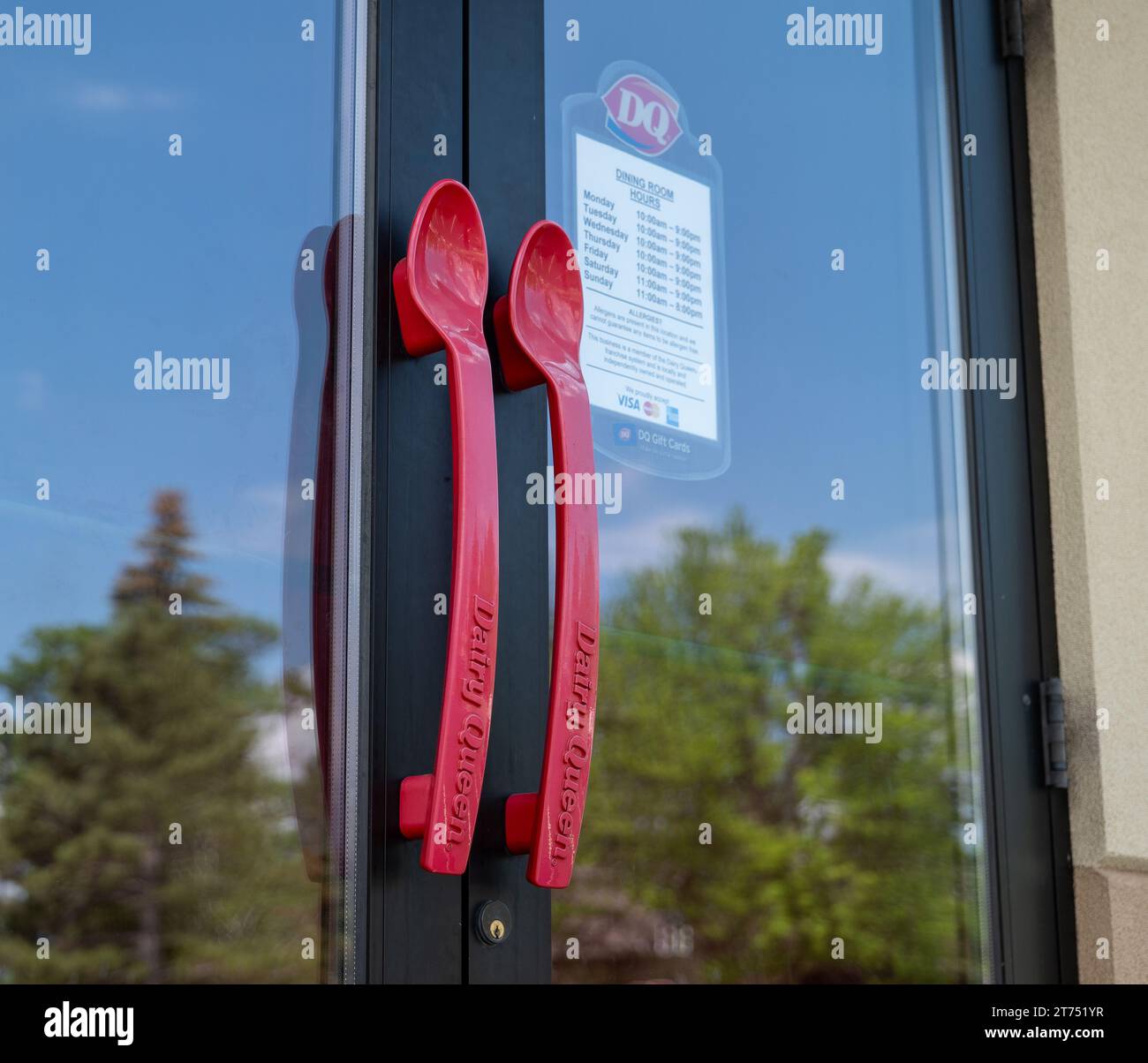 CASS LAKE, MN - 3 JUIN 2023 : poignées de porte d'entrée Dairy Queen en forme de cuillères en plastique rouges. Banque D'Images