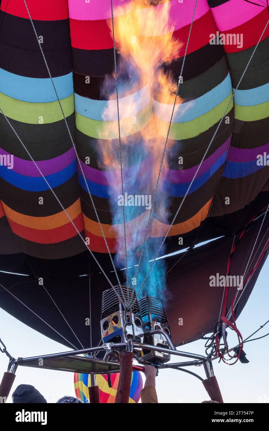 Les flammes bleues et orange d'un brûleur alimentent l'enveloppe d'un ballon multicolore gonflant à l'Albuquerque International ballon Fiesta Banque D'Images