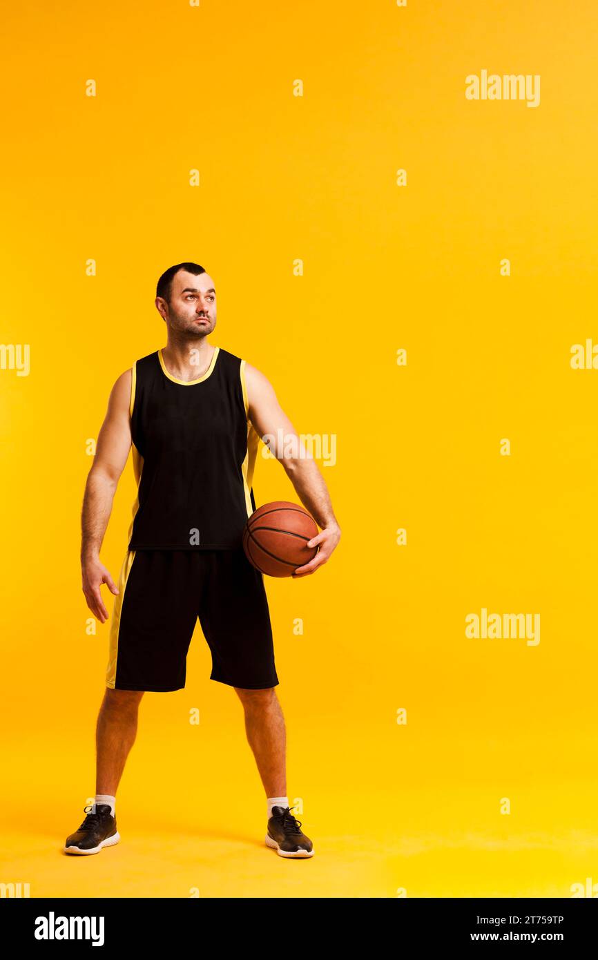 Joueur de basket-ball vue de face posant avec la balle près de l'espace de copie de hanche Banque D'Images