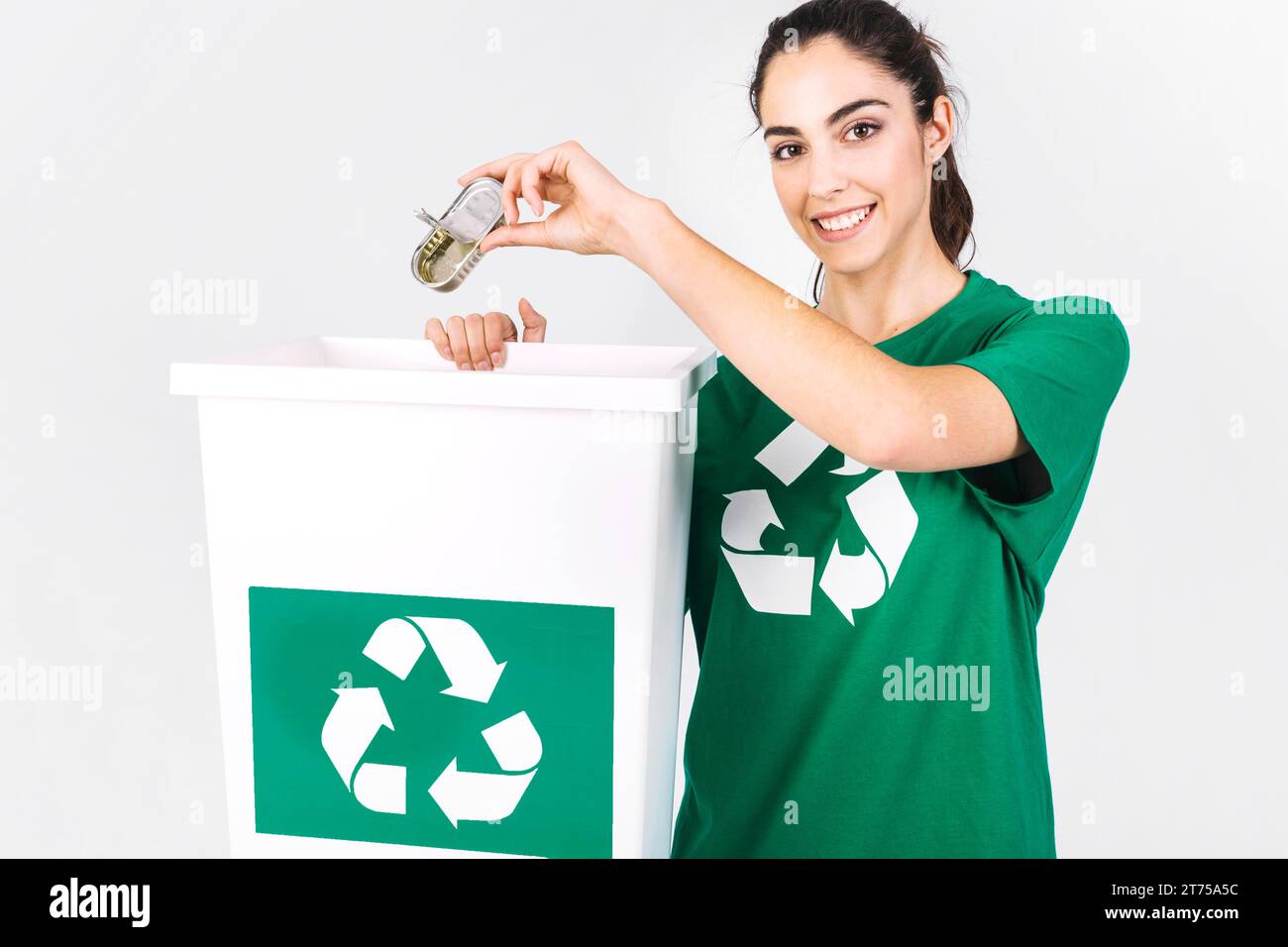 Heureuse jeune femme jetant mini tiffin boîte de recyclage poubelle Banque D'Images