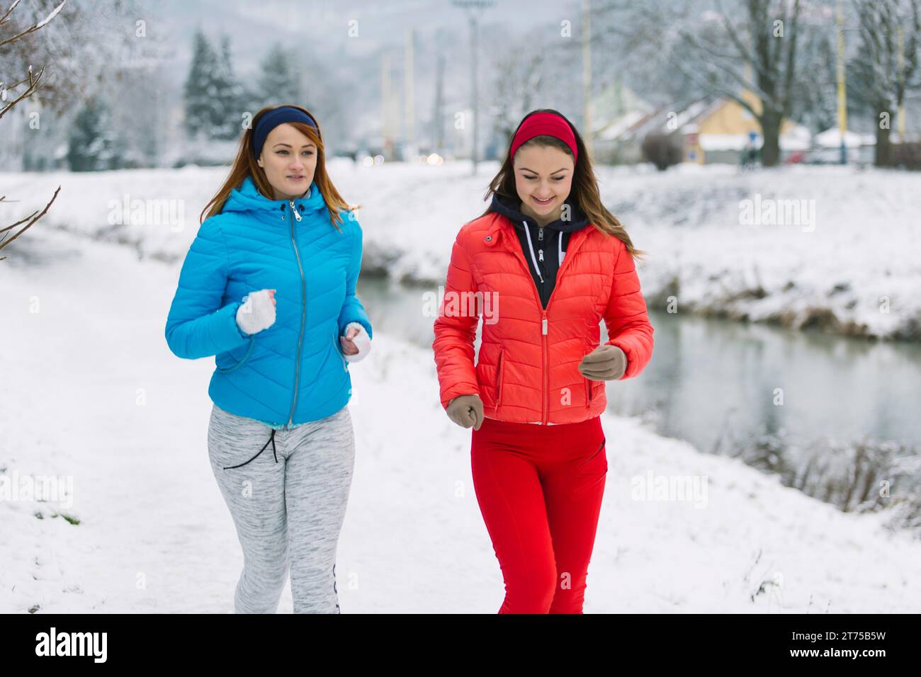 Souriant deux amies jogging saison d'hiver Banque D'Images