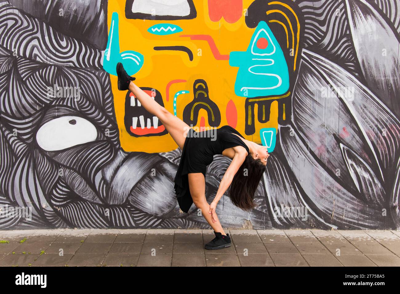 Danseuse de tango posant contre le mur de graffiti créatif Banque D'Images