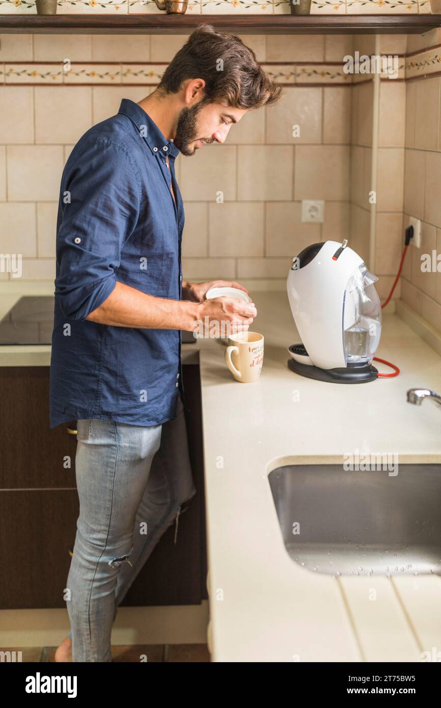 Jeune homme debout cuisine préparant le café Banque D'Images