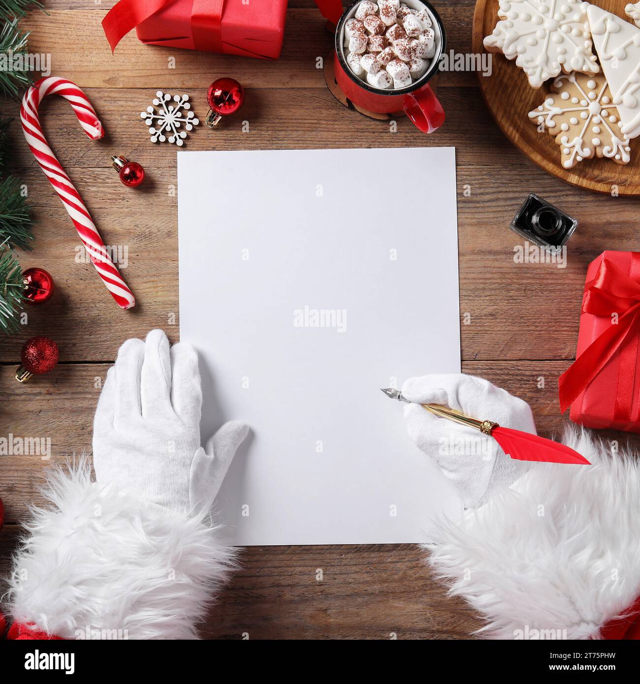 Père Noël avec lettre, plume et décoration de Noël à la table en bois, vue de dessus. Espace pour le texte Banque D'Images