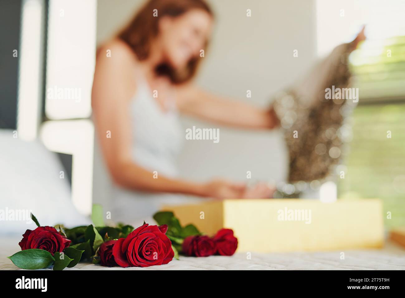 Femme, roses et boîte avec cadeau dans la chambre à coucher sur l'anniversaire, célébration et Saint Valentin événement à la maison. Fille, robe et mode avec bouquet, fleurs et Banque D'Images