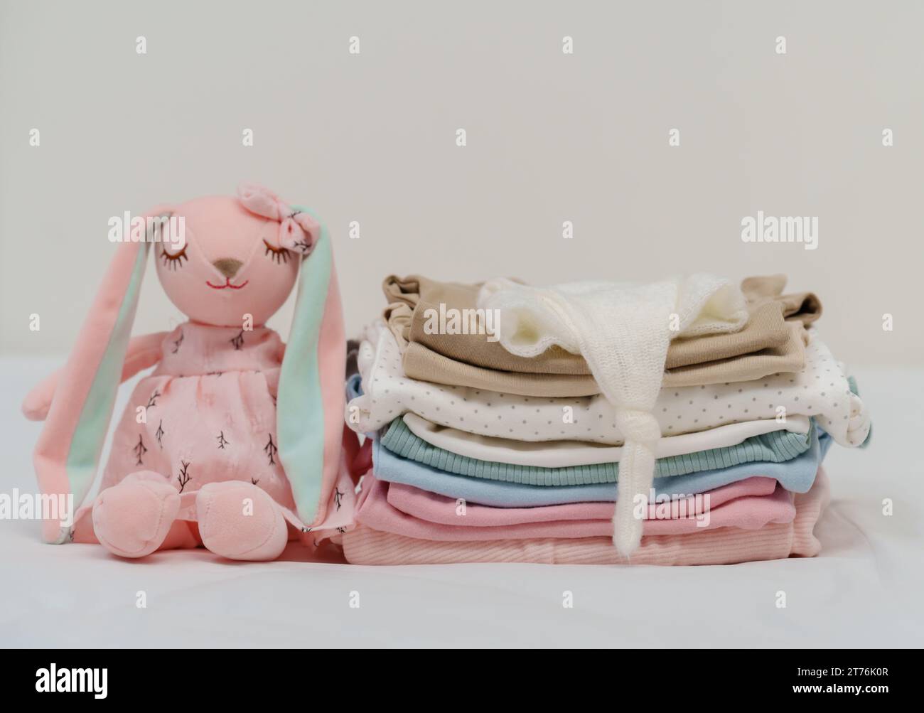 pile de vêtements de bébé et jouet sur un lit Banque D'Images