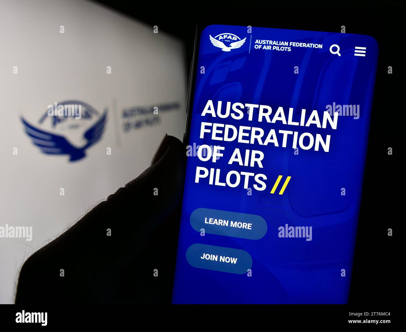 Personne détenant un smartphone avec une page Web de l'association Australian Federation of Air Pilots (AFAP) avec logo. Concentrez-vous sur le centre de l'écran du téléphone. Banque D'Images