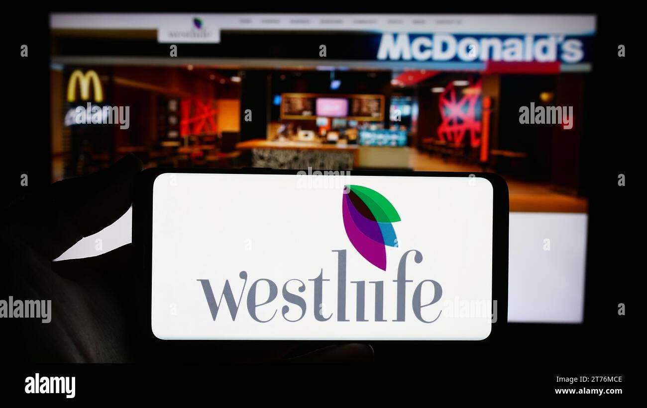 Personne tenant un smartphone avec le logo de la société indienne de restauration rapide Westlife Foodworld Limited devant le site Web. Concentrez-vous sur l'affichage du téléphone. Banque D'Images