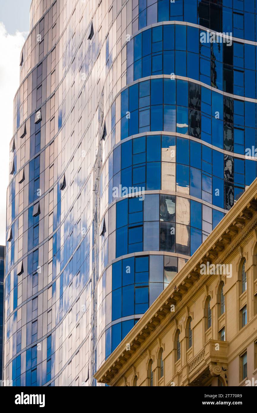 Vue rapprochée du reflet dans le verre sur le côté d'un immeuble de grande hauteur à Melbourne, Victoria, Australie. Banque D'Images