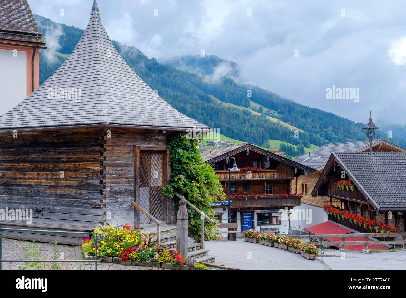 Bâtiments traditionnels en bois dans la ville alpine d'Alpbach, Autriche avec des nuages bas sur les collines. Banque D'Images