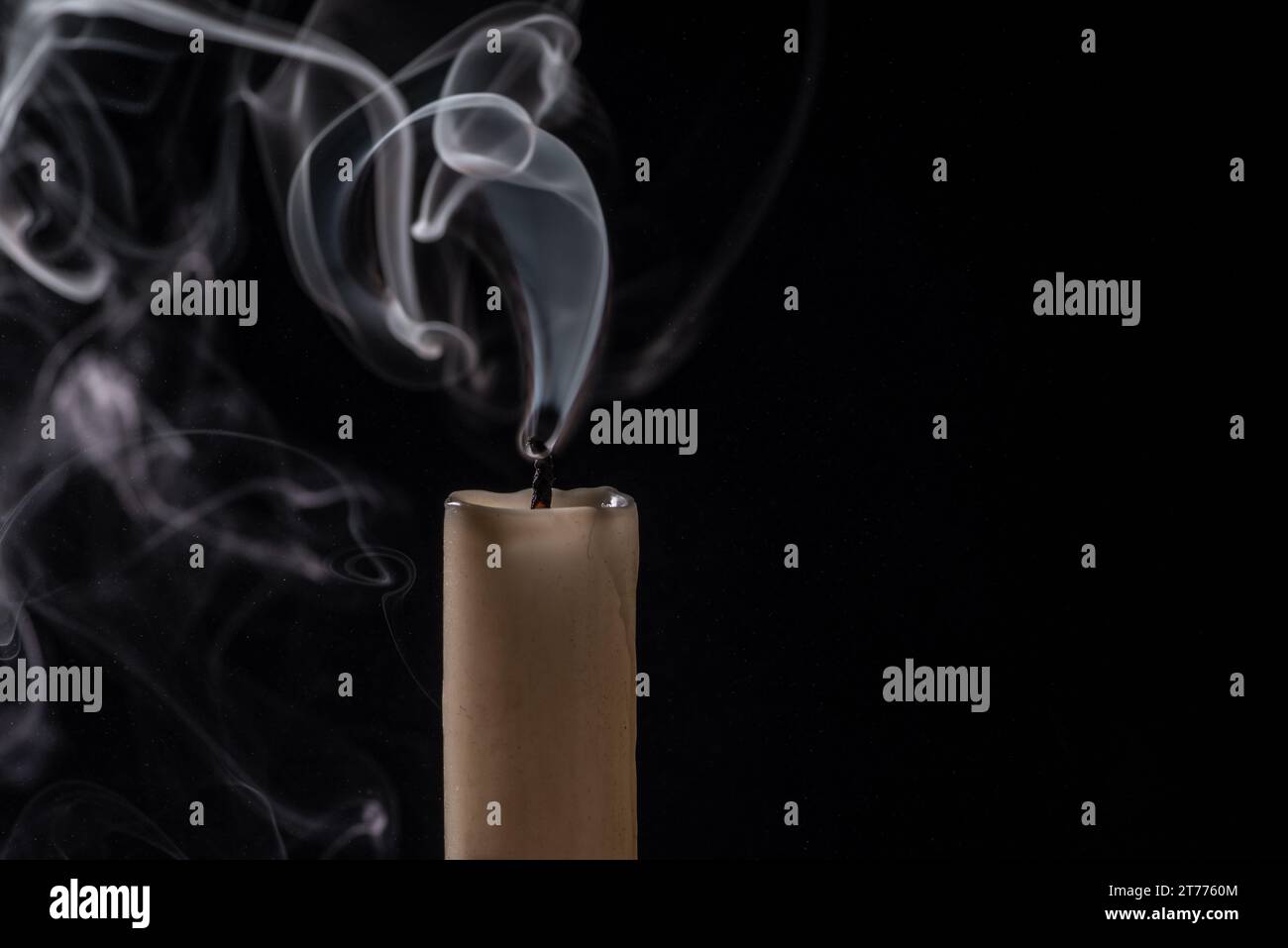 Une image isolée d'une cigarette allumée avec un mince brin de fumée qui s'enroule du haut Banque D'Images