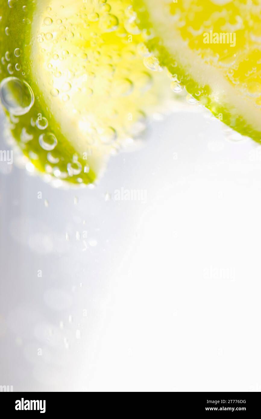Extreme close up de tranches de lime flottant dans l'eau pétillante Banque D'Images