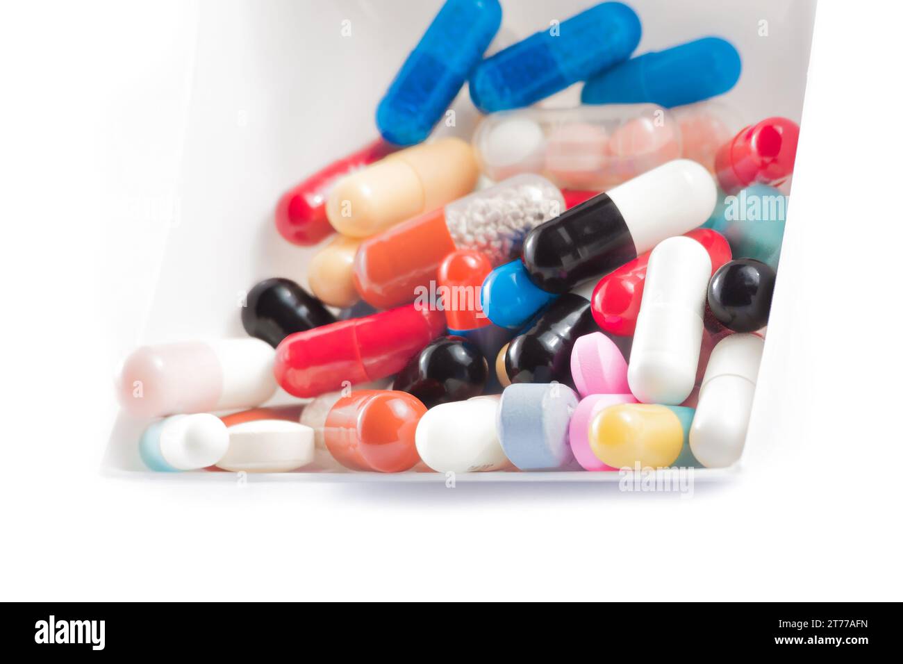 pilules colorées dans le récipient sur fond blanc Banque D'Images