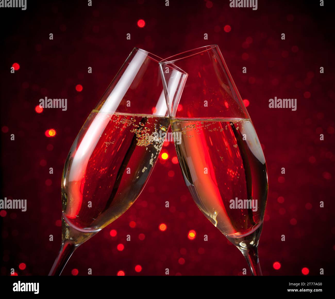 une paire de flûtes à champagne font des acclamations sur le fond de bokeh rouge sombre, la saint-valentin et les événements de noël Banque D'Images