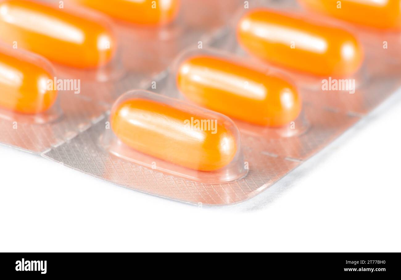 détail des pilules orange emballées dans blister sur la table blanche Banque D'Images