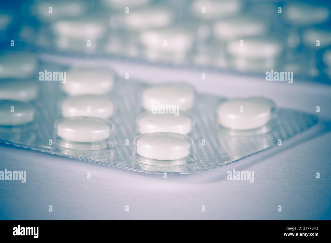 détail de la vue des pilules blanches emballées dans blister isolé sur table blanche Banque D'Images