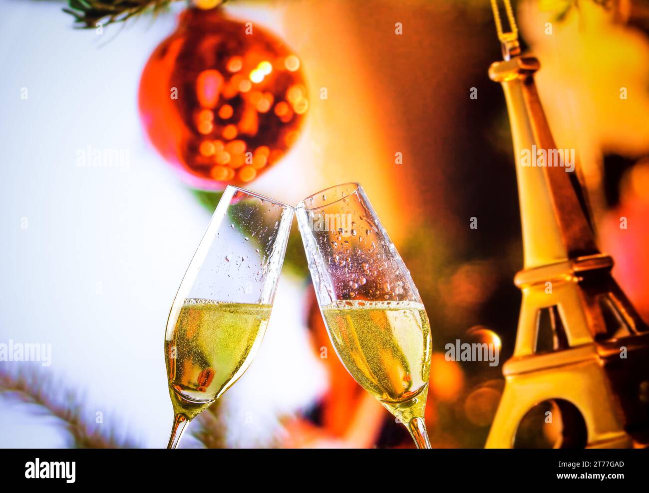 flûtes à champagne avec des bulles dorées font des acclamations sur fond de décoration eiffel de noël, ambiance paris de noël Banque D'Images