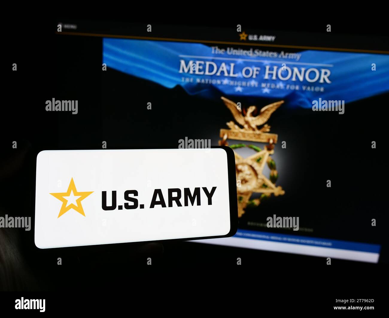Personne tenant le smartphone avec le logo de l'armée des États-Unis devant le site Web. Concentrez-vous sur l'affichage du téléphone. Banque D'Images