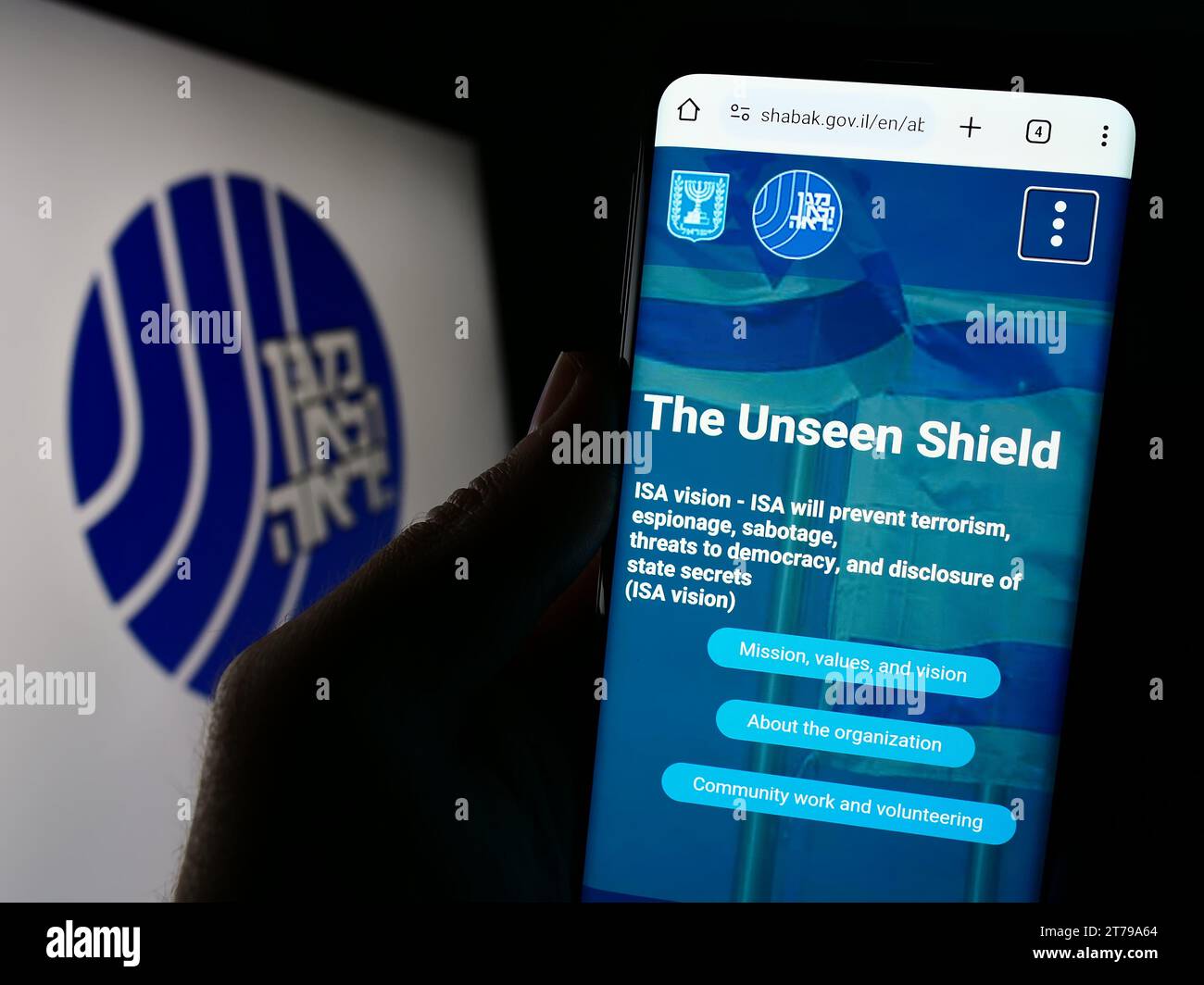 Personne tenant un téléphone portable avec le site de l'Agence de sécurité israélienne (ISA, Shin Bet) devant le logo. Concentrez-vous sur le centre de l'écran du téléphone. Banque D'Images