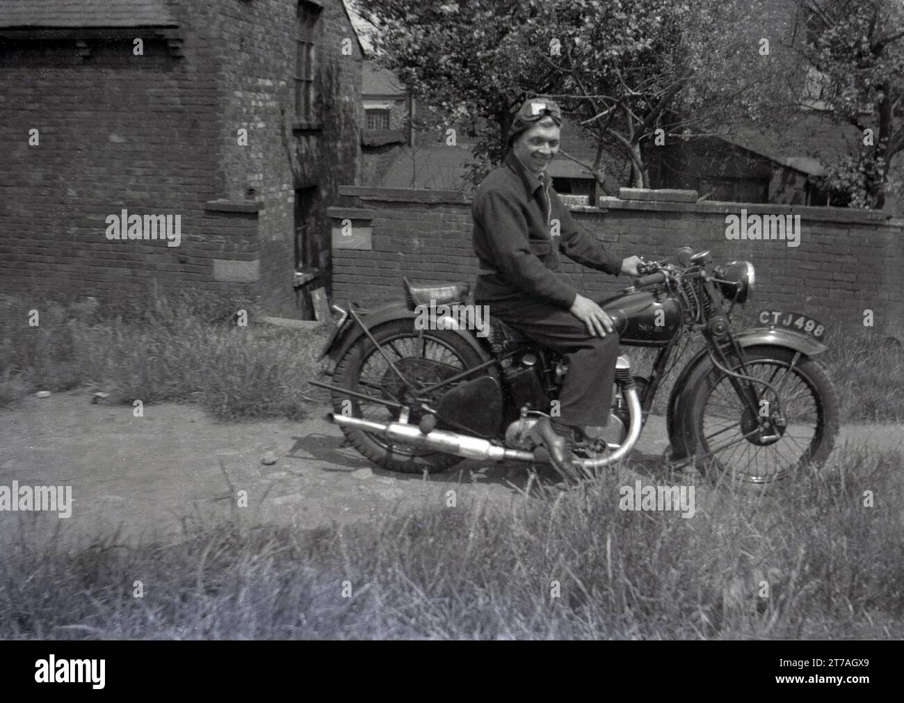 Années 1950 historique, un jeune homme avec chapeau et lunettes de visage assis sur une moto Sunbeam de l'époque, Oldham, Manchester, Angleterre, Royaume-Uni. Sunbeam cycles, une marque britannique de bicyclettes produite pour la première fois en 1887 par John Marston, qui en 1912 a commencé à fabriquer des motos à Woverhampton, qui a continué jusqu'en 1937, jusqu'à ce que la marque soit vendue à Associated Motor cycles (AMC). En 1943, AMC a vendu le nom Sunbeam à la plus grande société BSA, qui a continué la production jusqu'en 1956, lorsque les faibles ventes ont vu la fin de la production. Banque D'Images