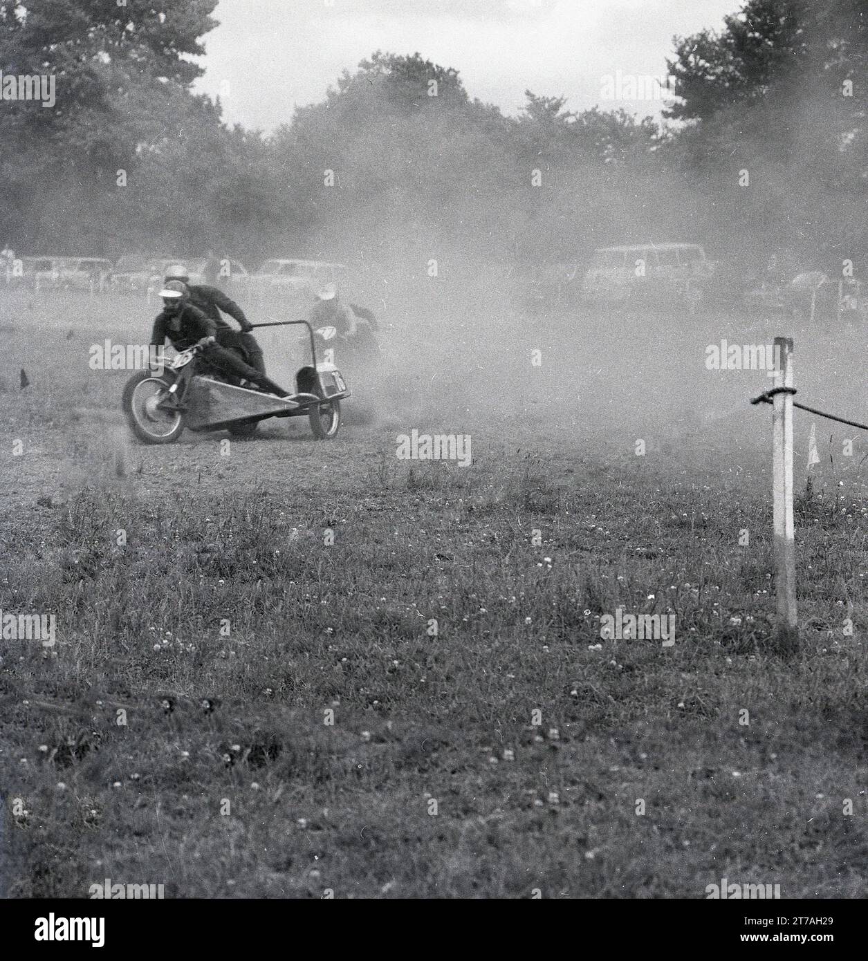 Années 1960, historique, concurrents, poussière qui s'écoule lors d'un side-car sur gazon speedway, Angleterre, Royaume-Uni. Banque D'Images