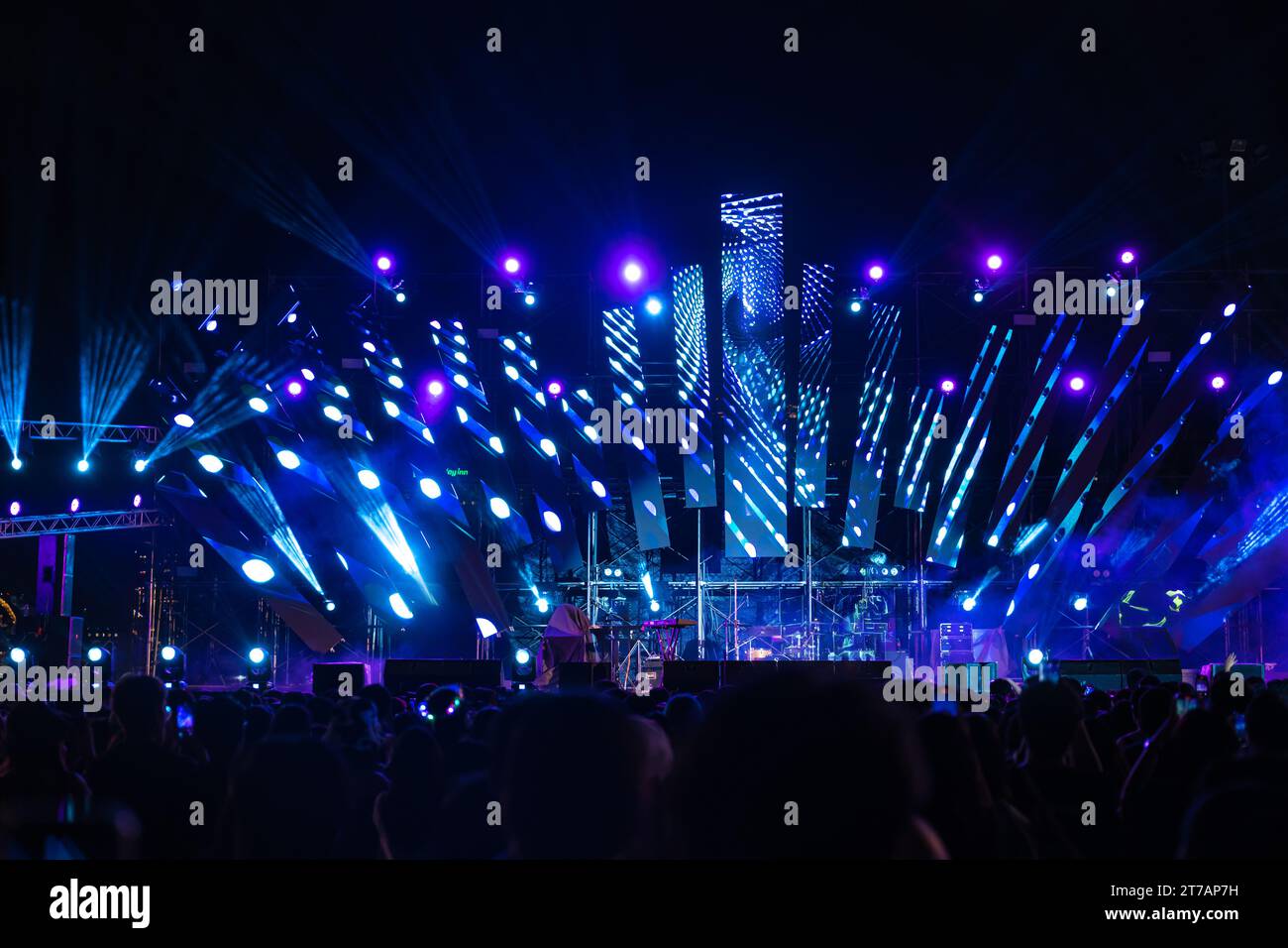 La nuit s’anime lors d’un festival de concert avec une foule jubilante devant les brillamment illuminés Banque D'Images