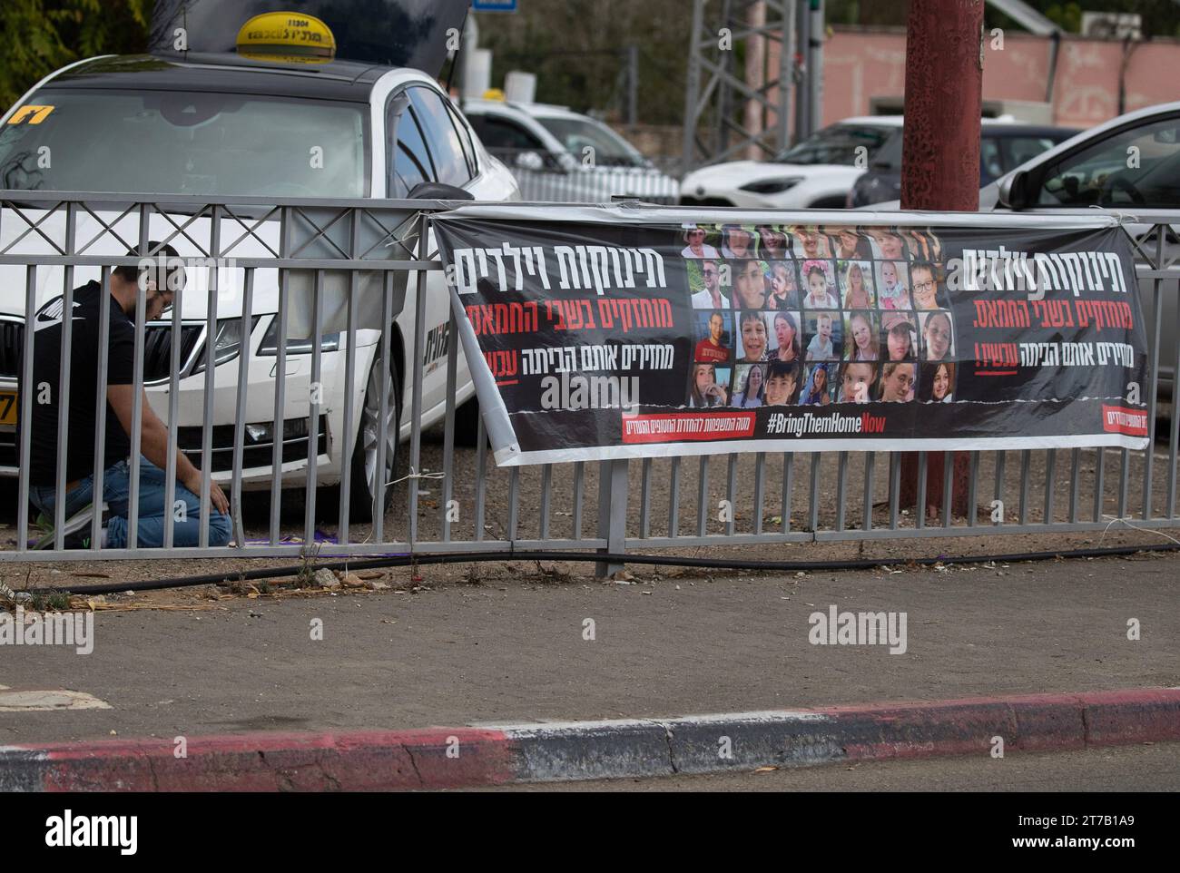 Israël central, Israël. 14 novembre 2023. Un arabe israélien musulman s’agenouille dans la prière dans le centre d’Israël le 14 novembre 2023, à côté d’une bannière appelant à les ramener à la maison, au sujet du retour des 240 personnes retenues en otage par le Hamas dans la bande de Gaza depuis le début de la guerre le 7 octobre 2023. Des bannières comme celles-ci sont placées partout en Israël au milieu des veillées et des manifestations pour ramener tous les otages à la maison. Photo de Jim Hollander/UPI crédit : UPI/Alamy Live News Banque D'Images Israël central, Israël. 14 novembre 2023. Un arabe israélien musulman s’agenouille dans la prière dans le centre d’Israël le 14 novembre 2023, à côté d’une bannière appelant à les ramener à la maison, au sujet du retour des 240 personnes retenues en otage par le Hamas dans la bande de Gaza depuis le début de la guerre le 7 octobre 2023. Des bannières comme celles-ci sont placées partout en Israël au milieu des veillées et des manifestations pour ramener tous les otages à la maison. Photo de Jim Hollander/UPI crédit : UPI/Alamy Live News Banque D'Images