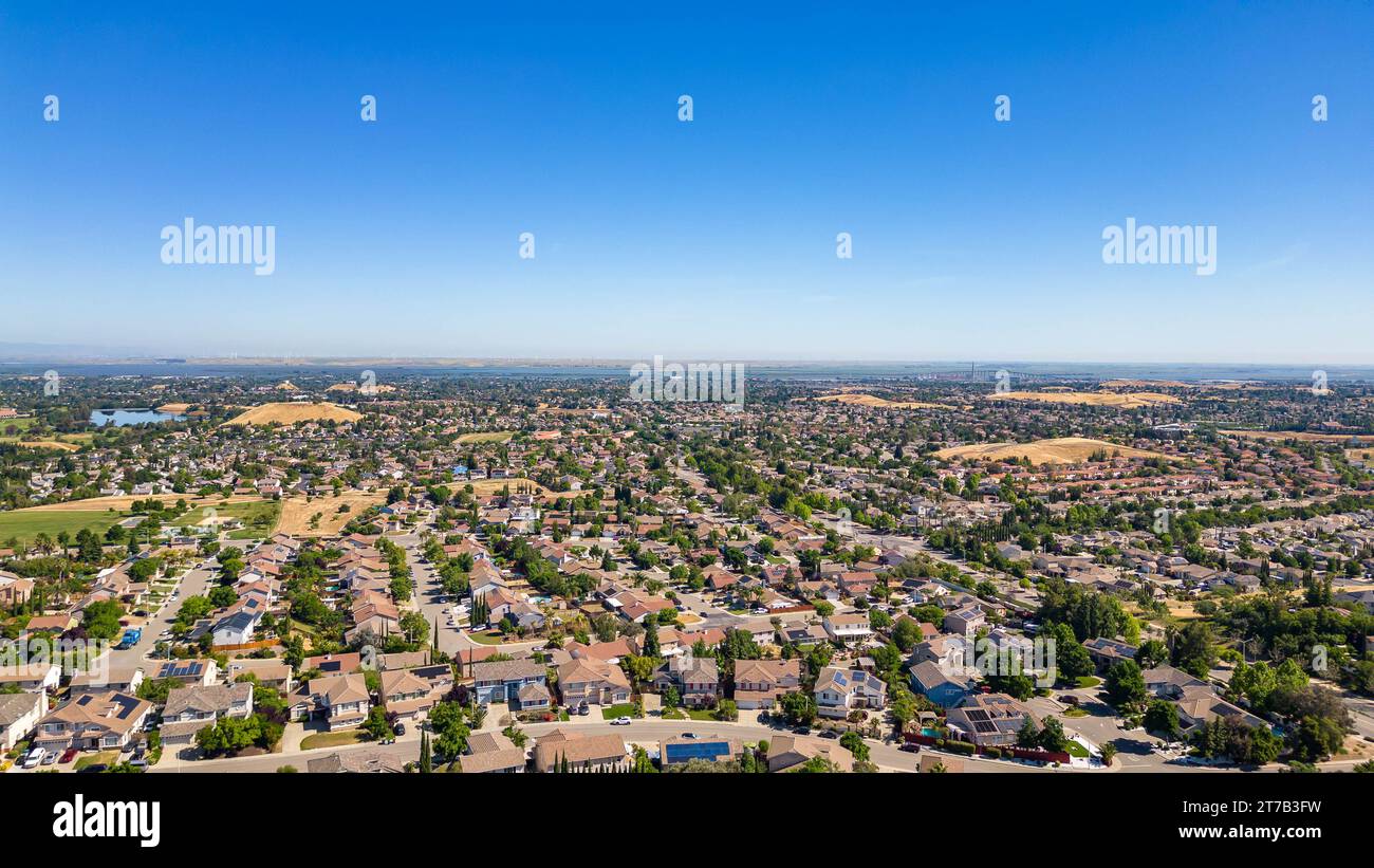Images aériennes au-dessus d'une communauté à Antioch, Californie avec des maisons avec des collines luxuriantes solaires et vertes après la pluie Banque D'Images