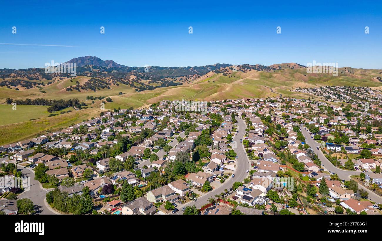 Images aériennes au-dessus d'une communauté à Antioch, Californie avec des maisons avec des collines luxuriantes solaires et vertes après la pluie Banque D'Images