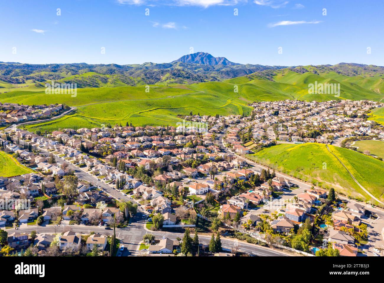 Images aériennes au-dessus d'une communauté à Antioch, Californie avec des maisons avec des collines luxuriantes solaires et vertes après la pluie Banque D'Images