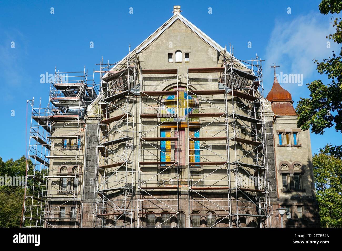 Réparation de la façade et du toit d'une ancienne église luthérienne en pierre à l'aide d'échafaudages de forme compliquée Banque D'Images