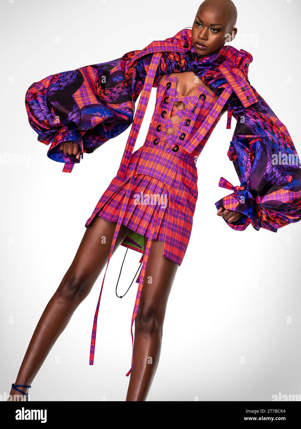 Portrait intégral d'un jeune mannequin africain portant une robe rose et violette extravagante. Banque D'Images