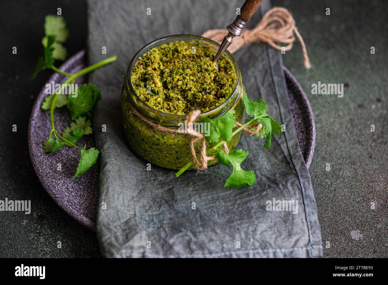 Savoureux adjika vert dans le pot en verre plat traditionnel de Géorgie Banque D'Images