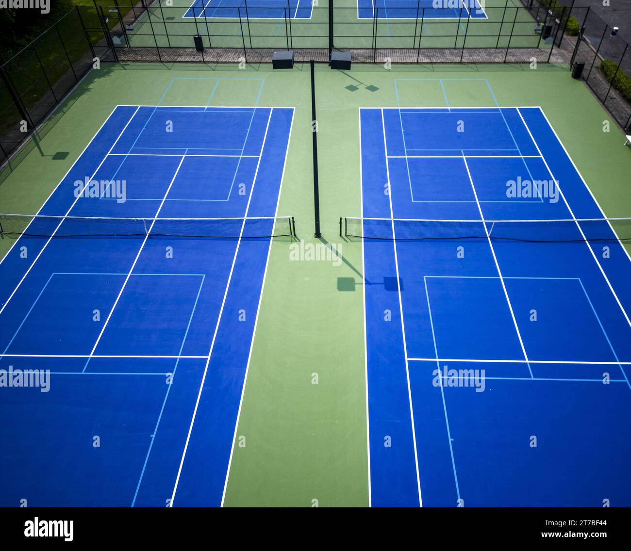 Une vue de drone regardant vers le bas les courts de pickleball bleus de tennis bordés de bleu clair pour le pickleball avec des lumières. Banque D'Images