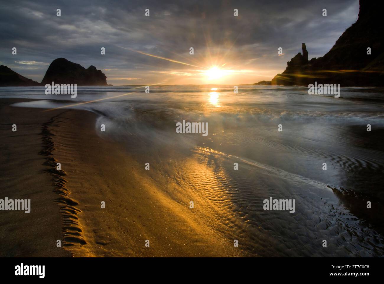 Coucher de soleil sur la plage de Piha, à l’ouest d’Auckland, sur l’île du Nord de la Nouvelle-Zélande. Banque D'Images