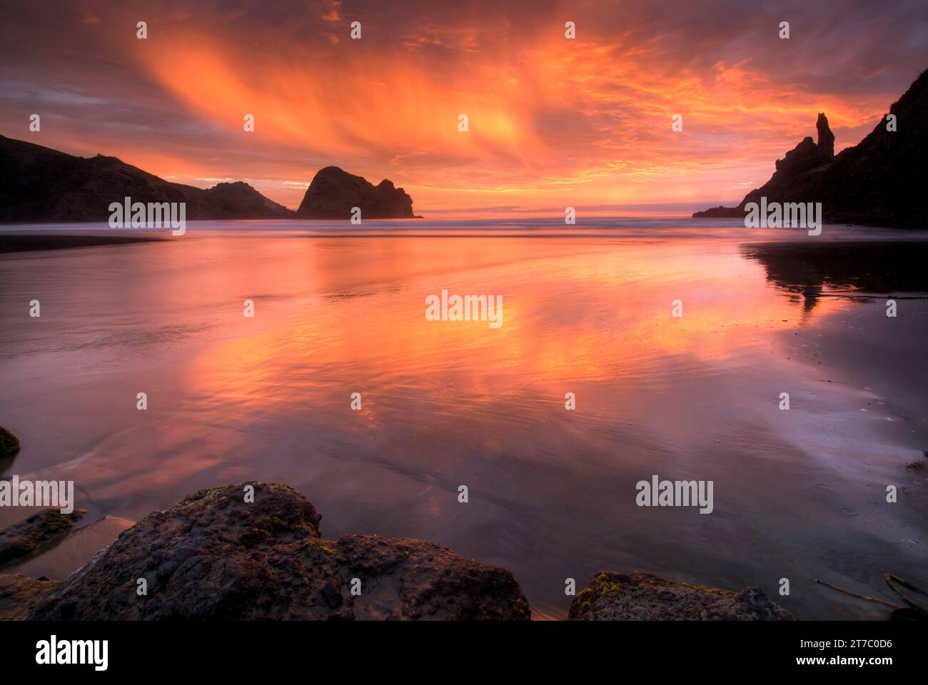 Coucher de soleil sur la plage de Piha, à l’ouest d’Auckland, sur l’île du Nord de la Nouvelle-Zélande. Banque D'Images