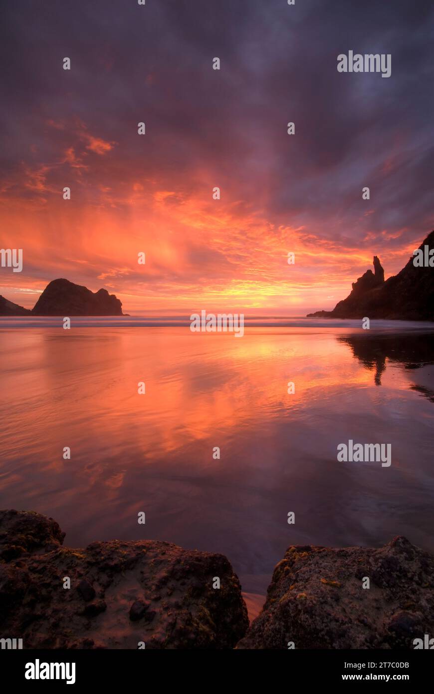 Coucher de soleil sur la plage de Piha, à l’ouest d’Auckland, sur l’île du Nord de la Nouvelle-Zélande. Banque D'Images