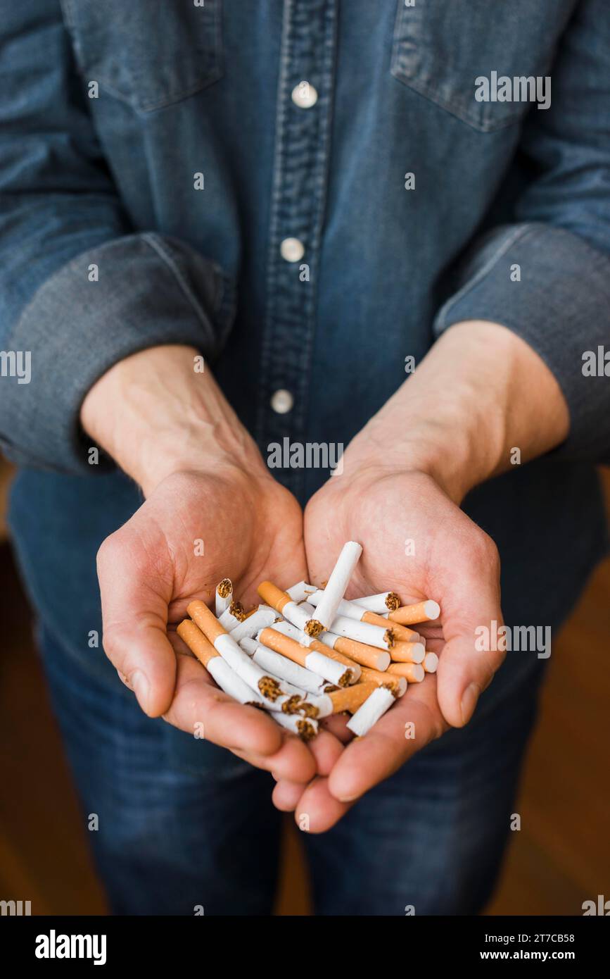 Vue à angle élevé cigarettes cassées main de l'homme Banque D'Images
