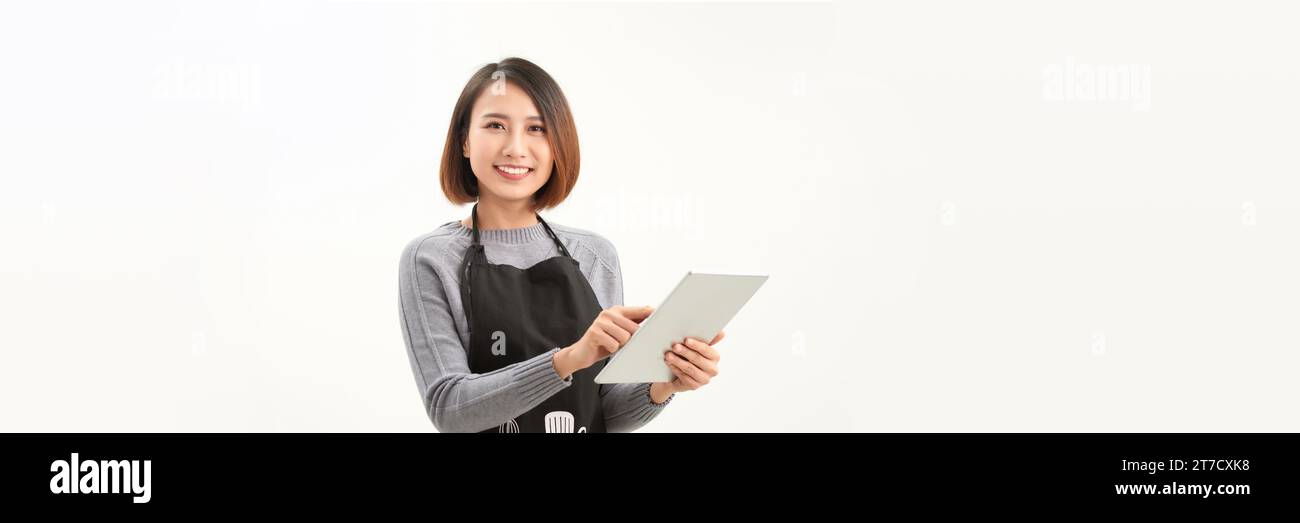 Portrait de jeune serveuse asiatique de café à l'aide d'une tablette numérique sur fond blanc Banque D'Images