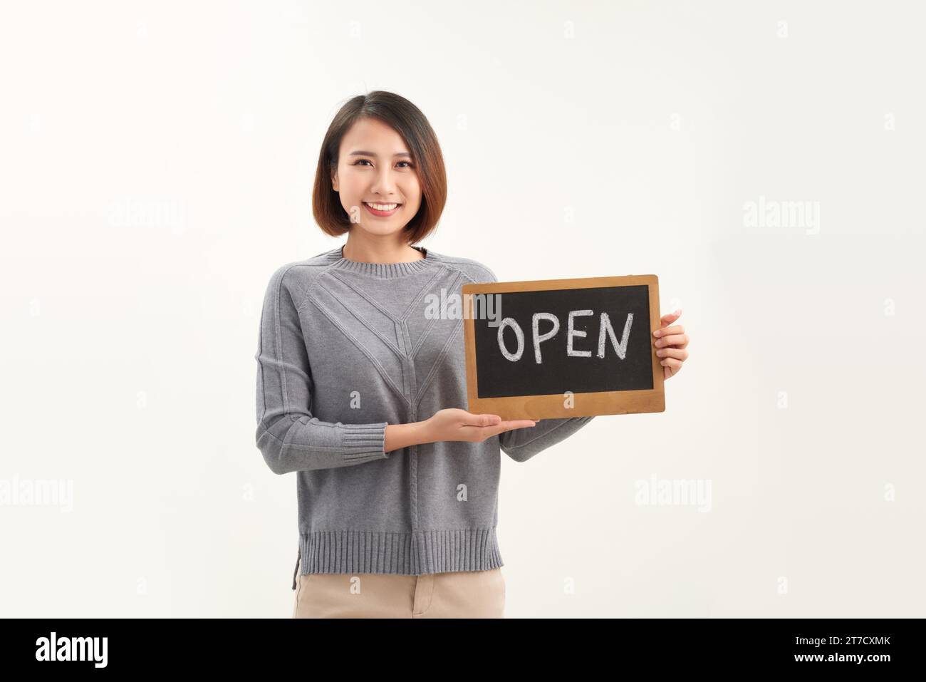 Portrait du jeune beau propriétaire de café asiatique tenant le signe ouvert. Banque D'Images