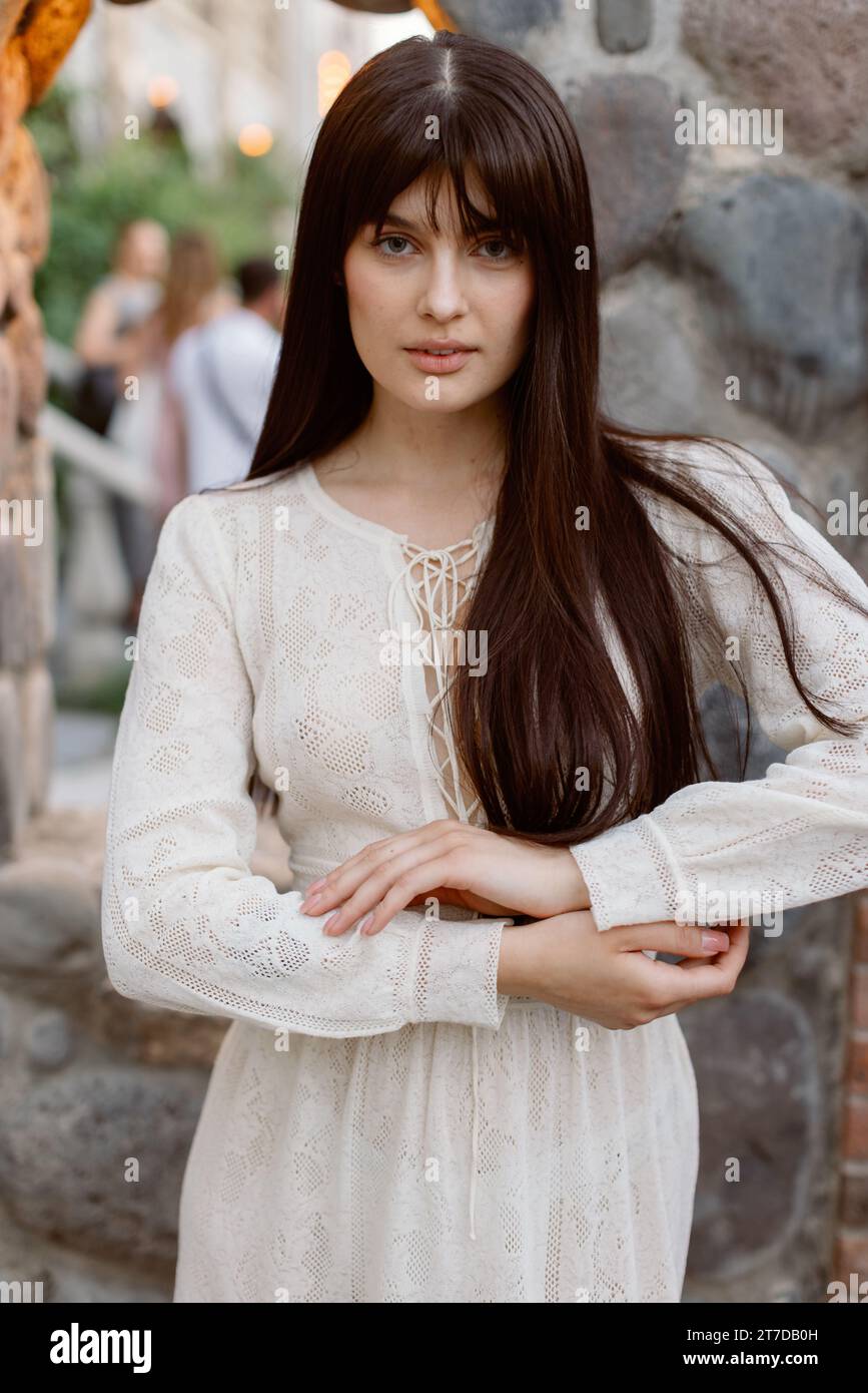 Portrait d'une jolie femme caucasienne portant une longue robe blanche fluide Banque D'Images