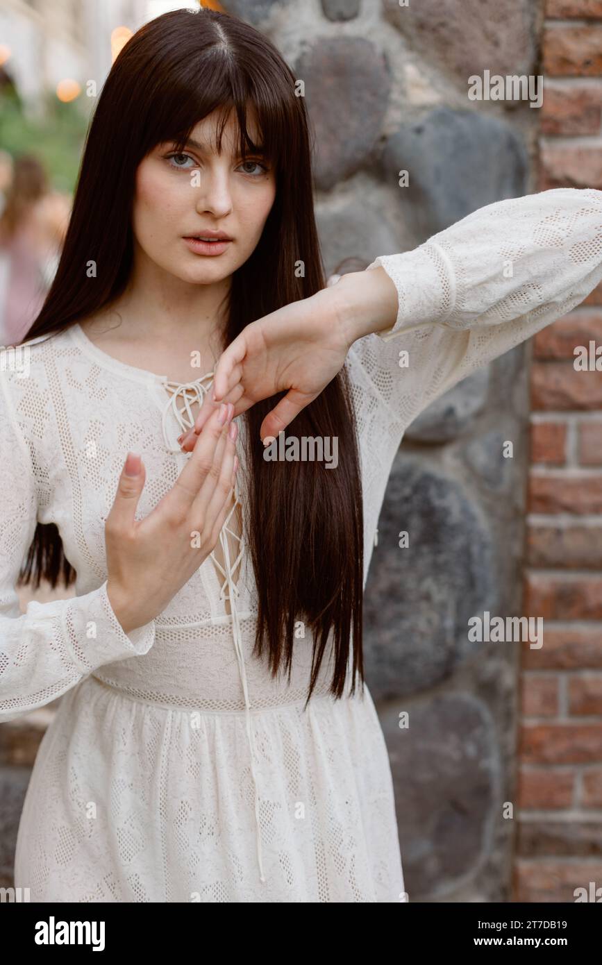 Portrait d'une jolie femme caucasienne portant une longue robe blanche fluide Banque D'Images