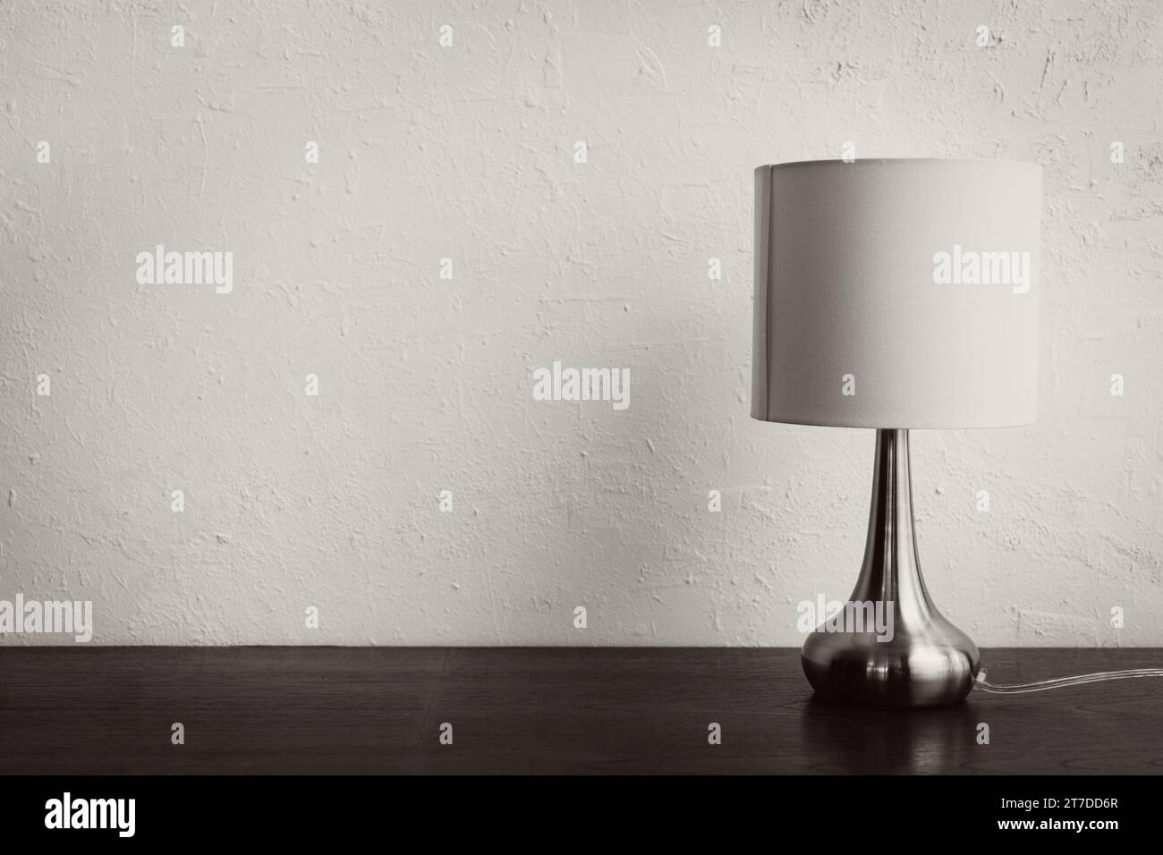 lampe élégante simple minimale sur table en bois contre mur blanc Banque D'Images