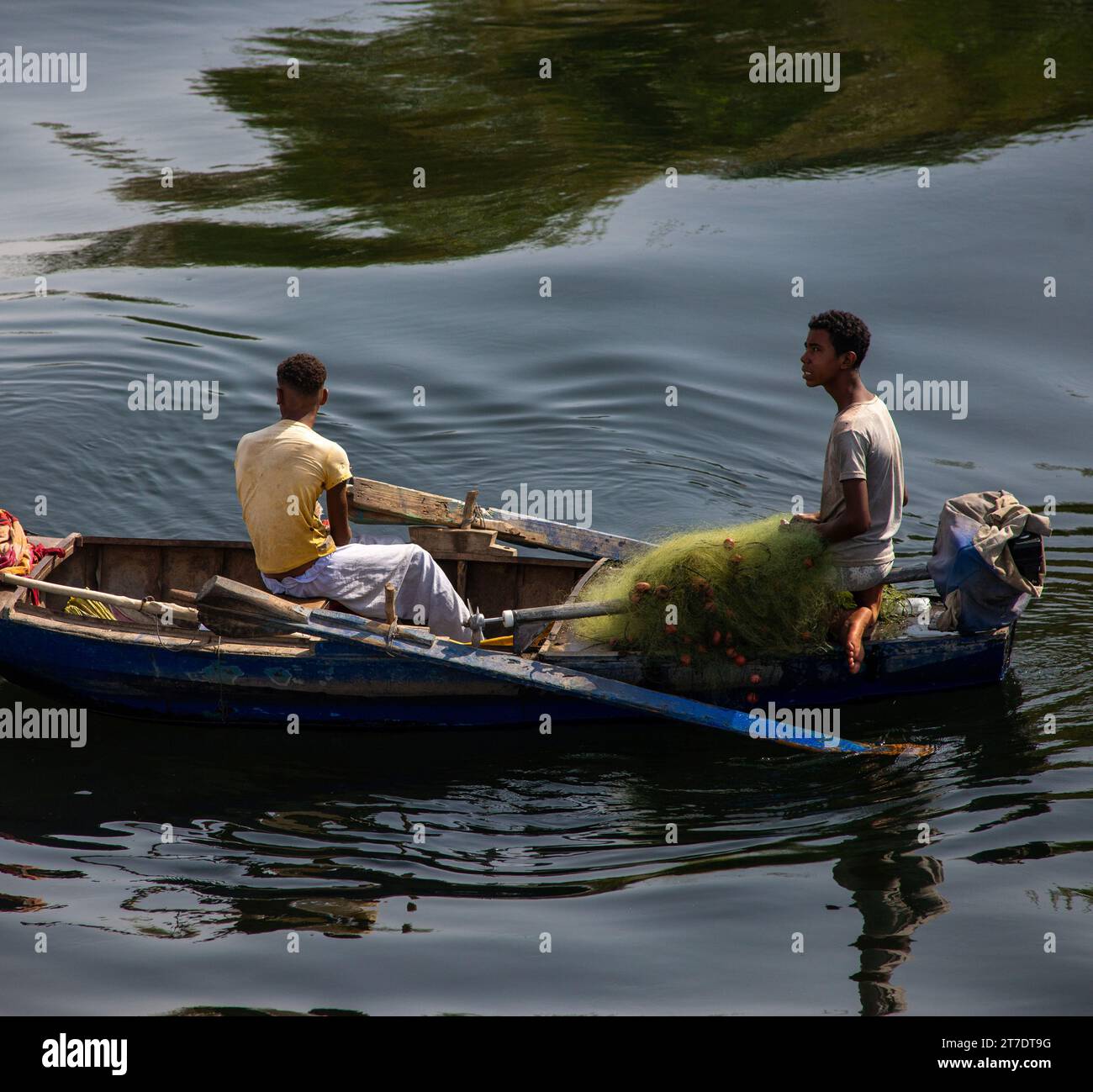 Deux jeunes dans un bateau de pêche traditionnel avec des filets sur le Nil Banque D'Images