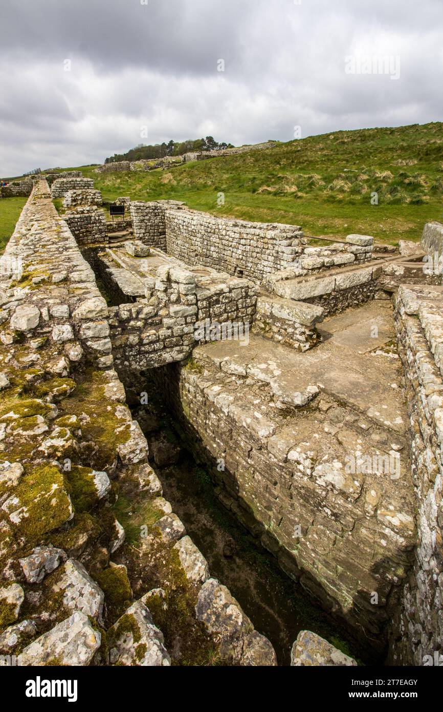 Les ruines des latrines publiques romaines à Housesteads fort le long du mur d’Hadrien dans le nord du Royaume-Uni, avec des nuages de tempête qui se rassemblent en arrière-plan Banque D'Images