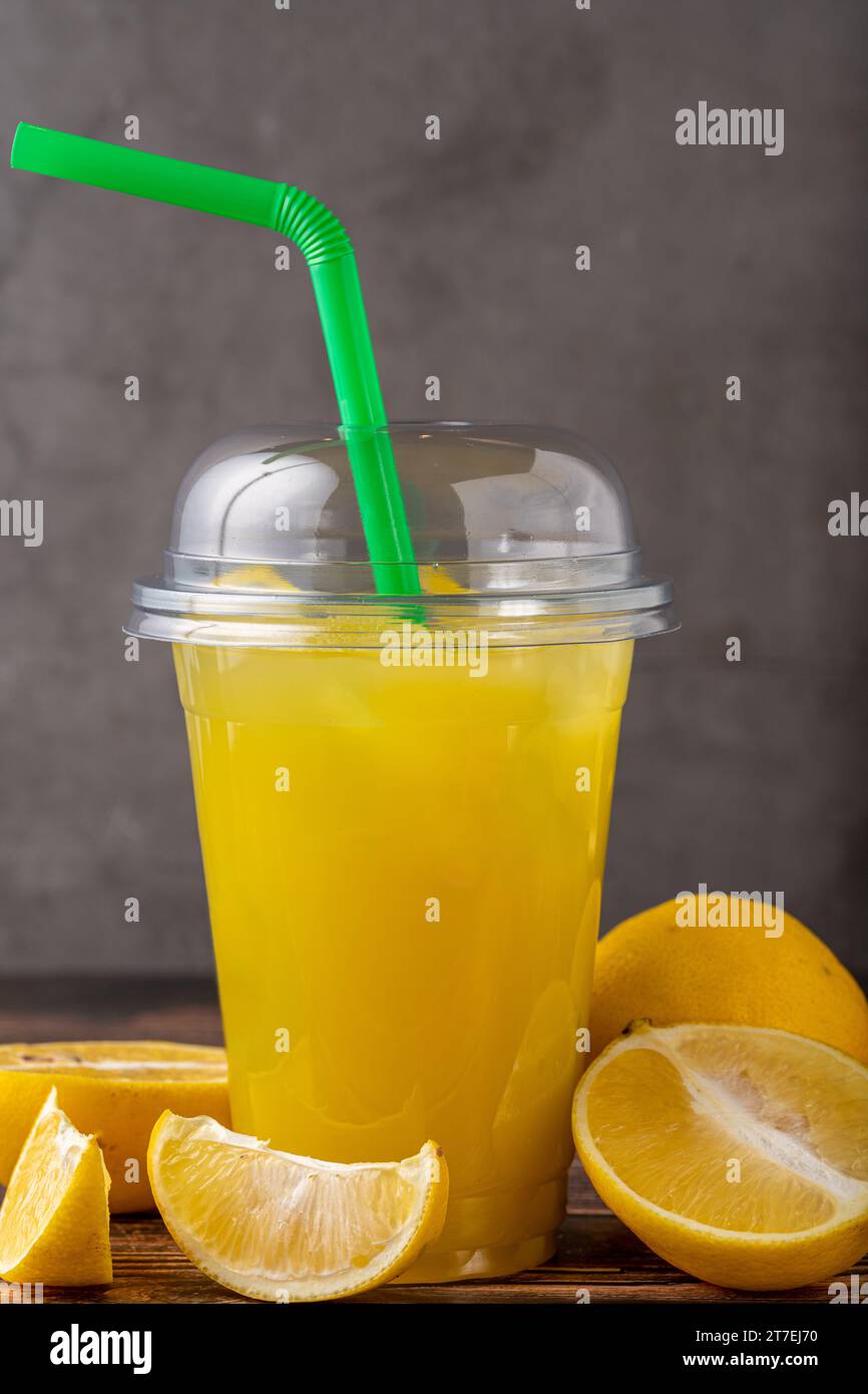 Limonade glacée en verre plastique sur table en bois Banque D'Images