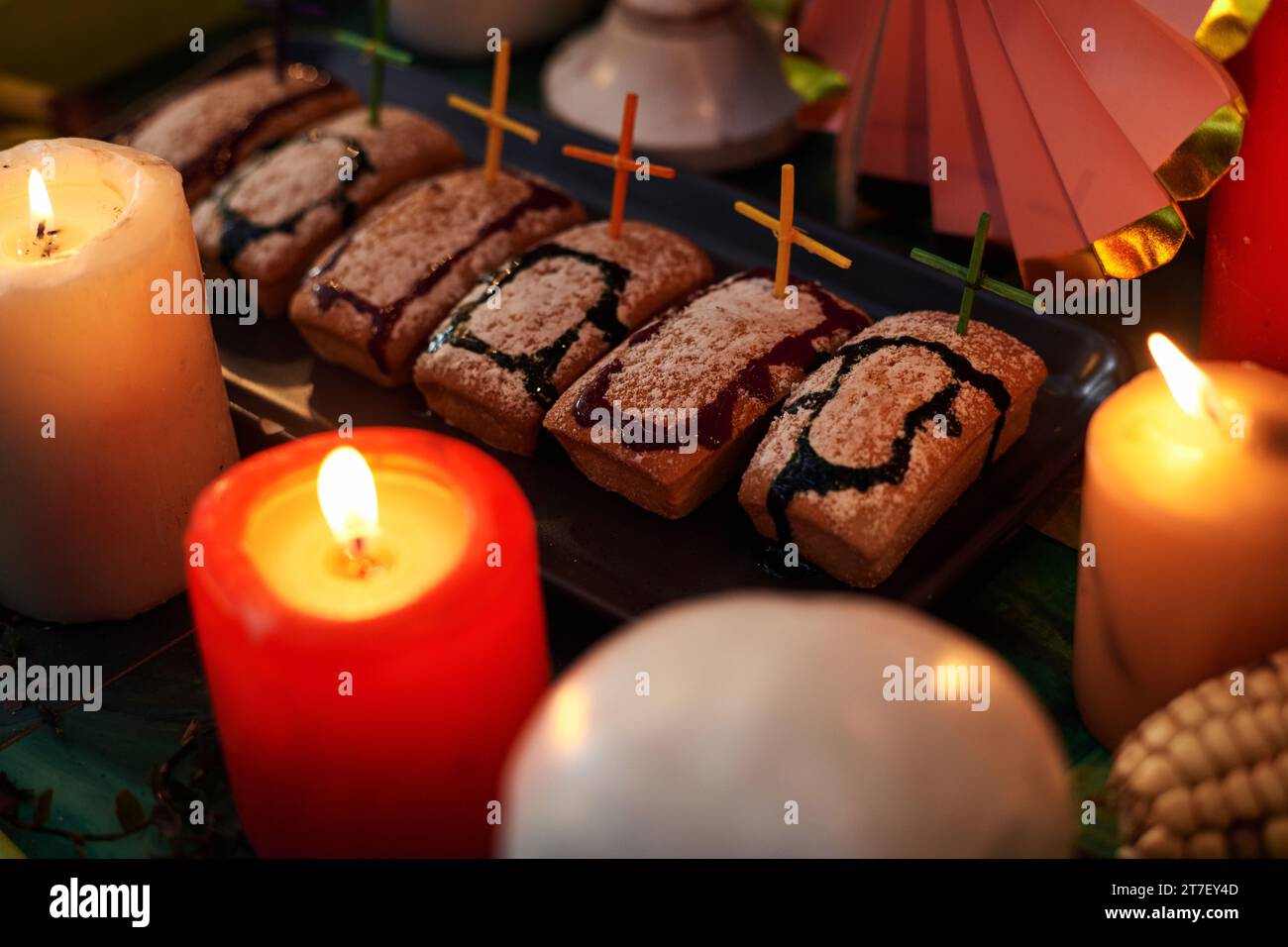 Gros plan de gâteaux faits maison cuits en forme de tombes décorant avec des croix avec des bougies sur la table Banque D'Images