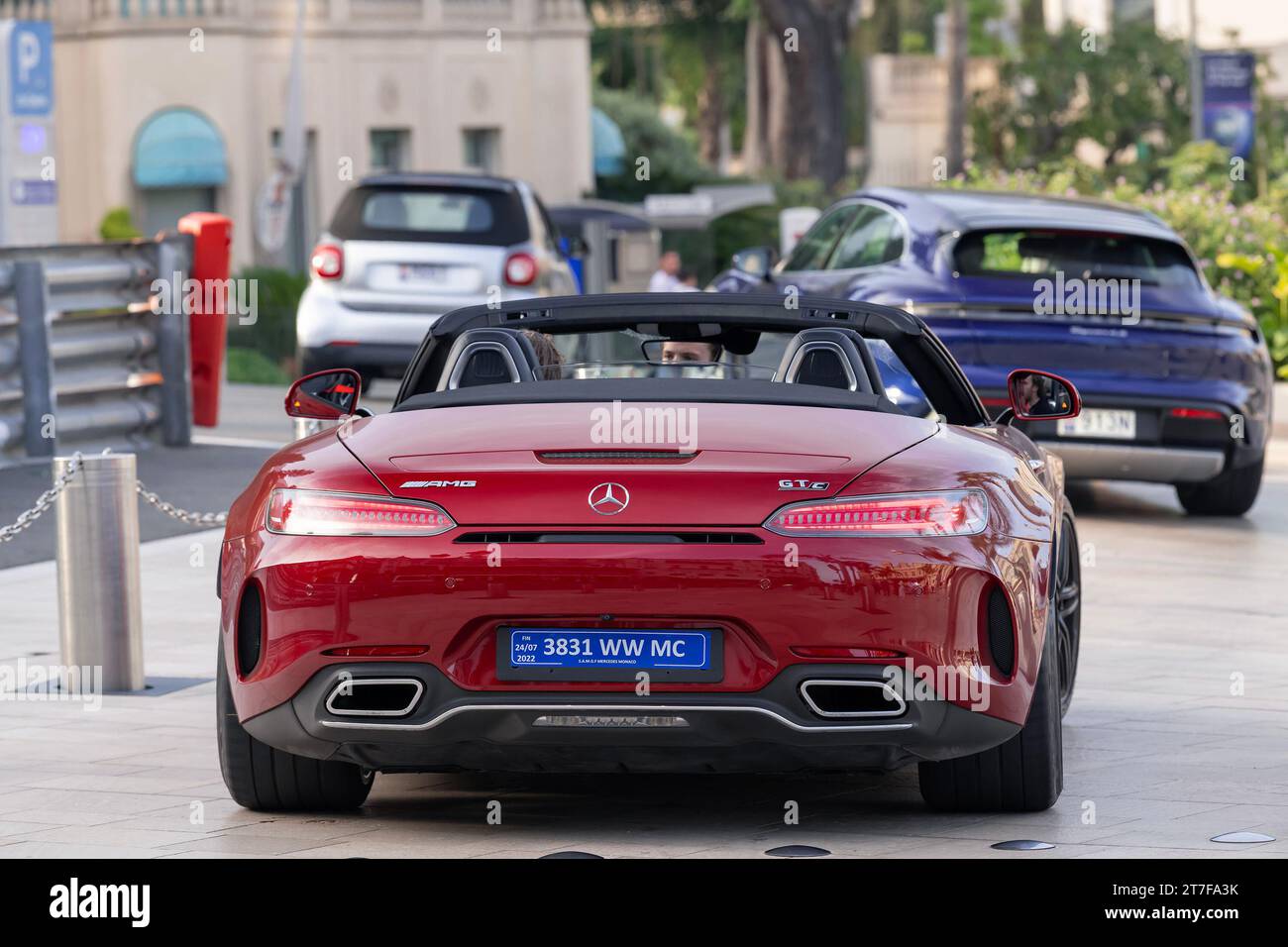 Monte Carlo, Monaco - Bourgogne Mercedes-AMG GT C Roadster conduite sur la place du Casino. Banque D'Images