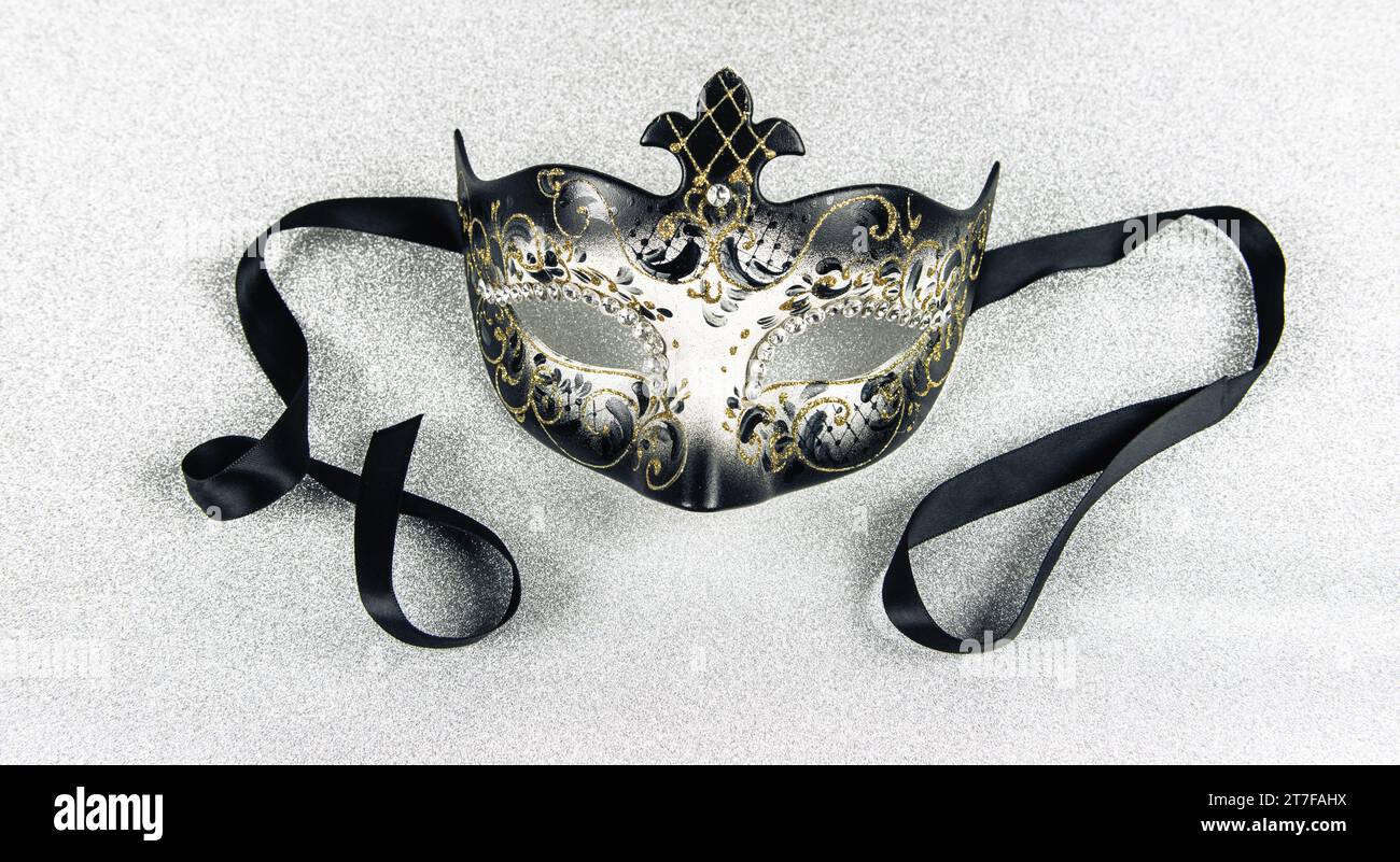 Masque de carnaval avec ruban noir sur fond brillant argenté. Gros plan. Banque D'Images